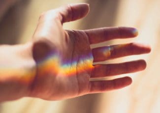 hand with a rainbow shining on it